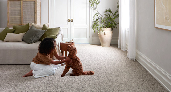 lady and pet dog sitting on livingroom carpet