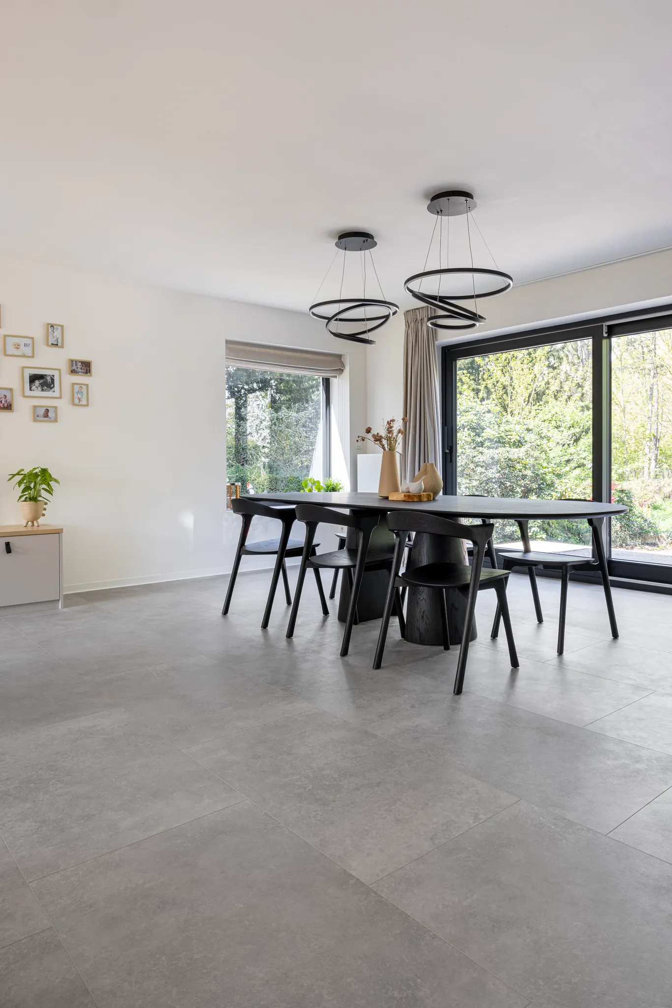 Modern dining room with black table and chairs and concrete Coretec tile