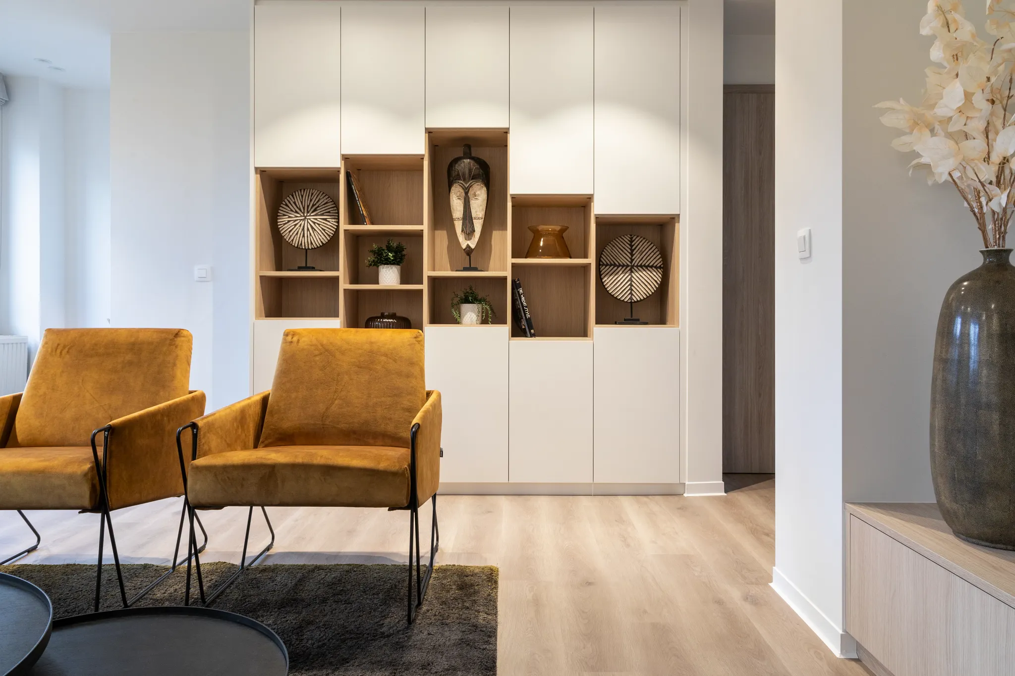 Modern living room with light wood look luxury vinyl plank flooring and mustard yellow chairs