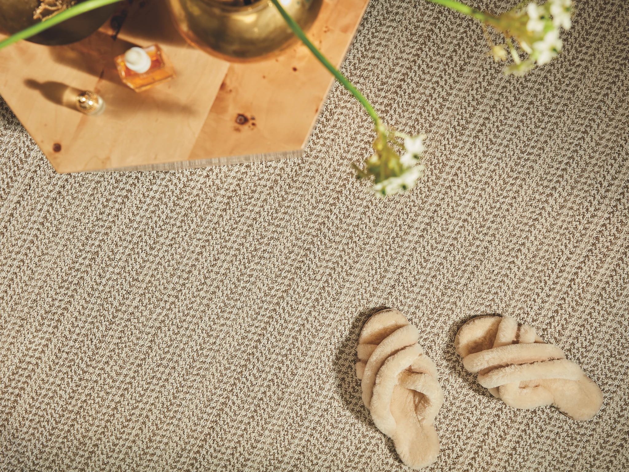 Close-up view of beige textured carpet flooring with a wooden tray and decorative items