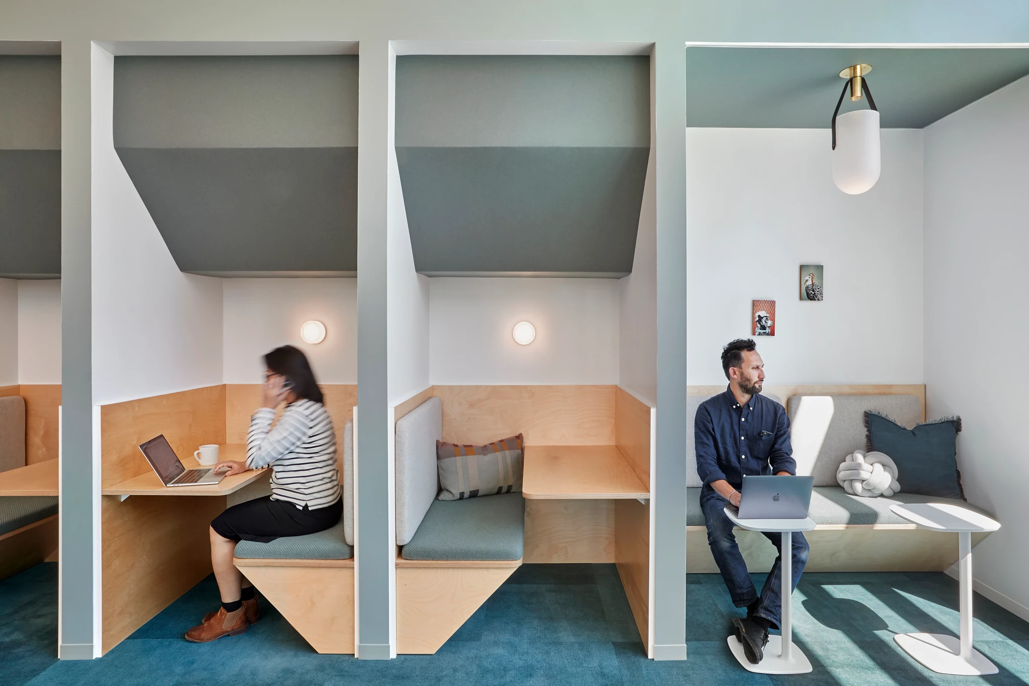 Modern workplace with private seating booths and blue carpet flooring