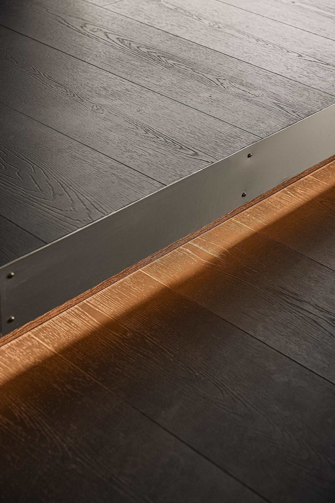 Close-up black wooden Coretec floor with level and integrated lighting