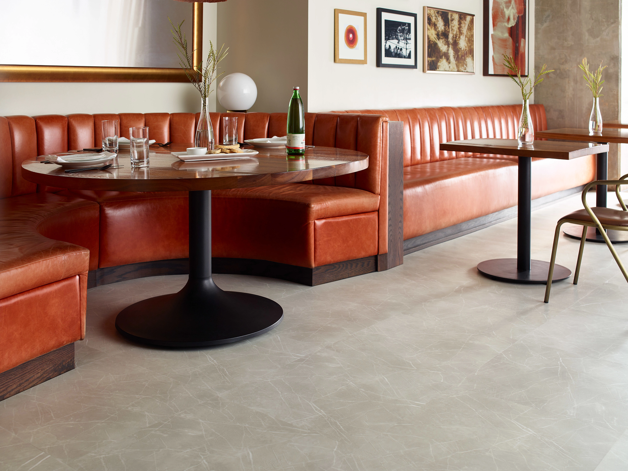 
  "Modern dining area with high performance luxury vinyl tile flooring in a light beige color, featuring 23.62x23.62 inch tiles and brown leather seating"
)