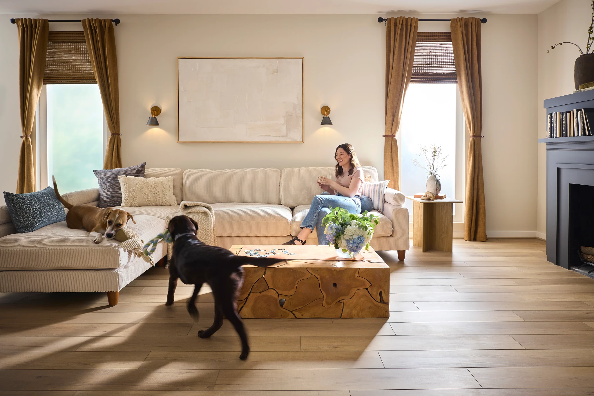 living room with luxury vinyl plank floor in a wood look with a woman on a sofa with two dogs playing 4803x709 inch planks