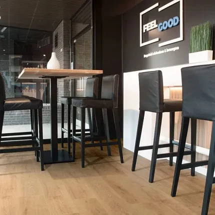Light Wood Look LVP Flooring in Contemporary Dining Space Modern dining area with light wood look luxury vinyl plank flooring and black leather chairs