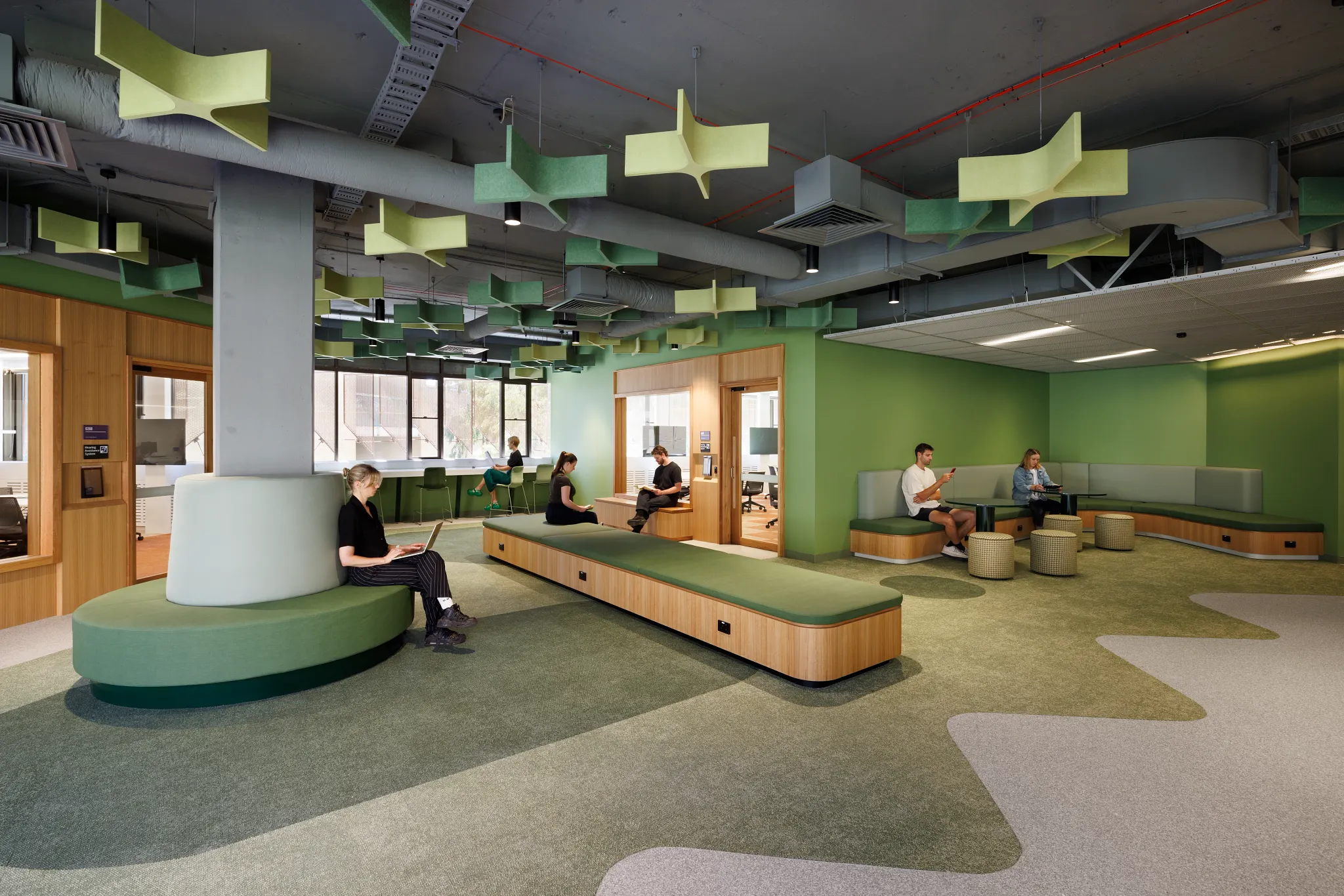 Open learning and collaboration area at Victoria University featuring integrated timber seating, green acoustic ceiling panels, flexible study zones and Shaw Contract flooring.