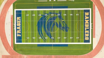 Artificial Turf Sports Field with Blue and Yellow Design Aerial view of a sports field with artificial turf featuring a blue and yellow design