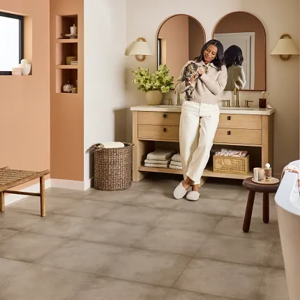 Luxury Vinyl Tile Flooring in Modern Bathroom Design Modern bathroom with luxury vinyl tile flooring in a neutral stone look, featuring a freestanding bathtub and wooden vanity