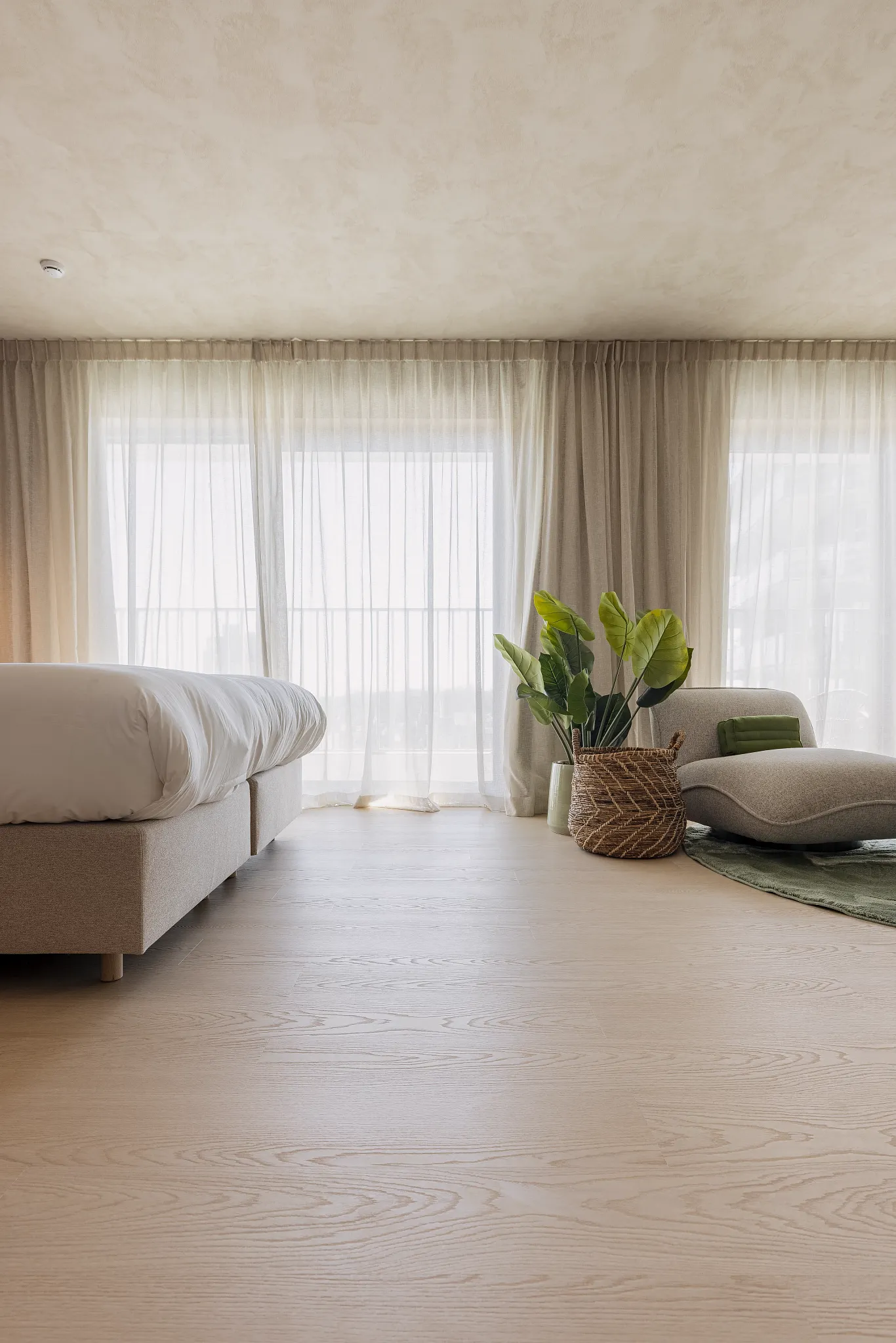 Hotel room with light furniture and light wooden Coretec floor