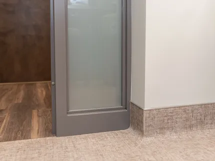 Contemporary flooring design with wood-look and beige baseboard Modern room scene with wood-look hard surface flooring and beige textured baseboard