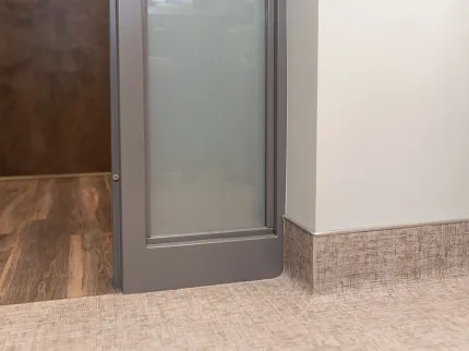 Contemporary flooring design with wood-look and beige baseboard Modern room scene with wood-look hard surface flooring and beige textured baseboard