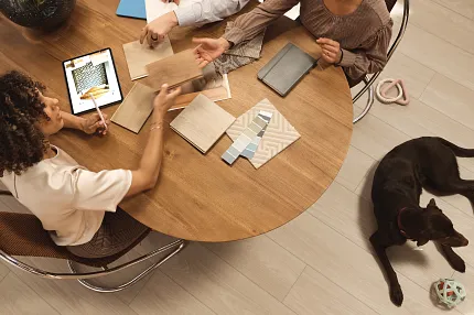 Design Center image Couple sitting at a design center desk looking at swatches of flooring and paint