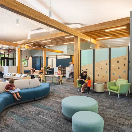 Education Facility with Commercial Carpet Tile Flooring in Library Setting Modern education facility with children and adults in a library setting featuring commercial carpet tile flooring in shades of gray and blue