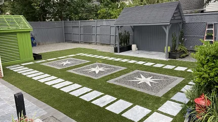 Stylish outdoor design with synthetic turf and paving stones Modern backyard with artificial grass and stone tiles