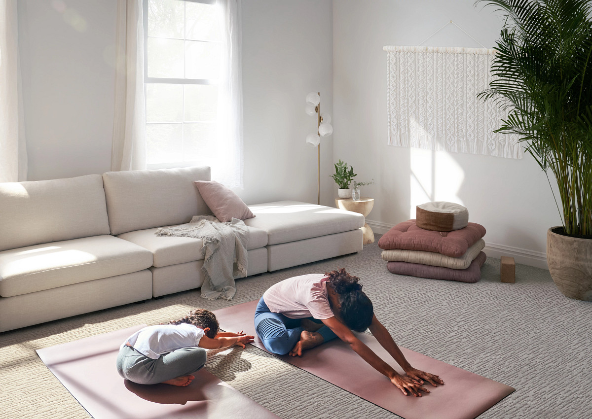 A woman and her daughter doing yoga in the living room