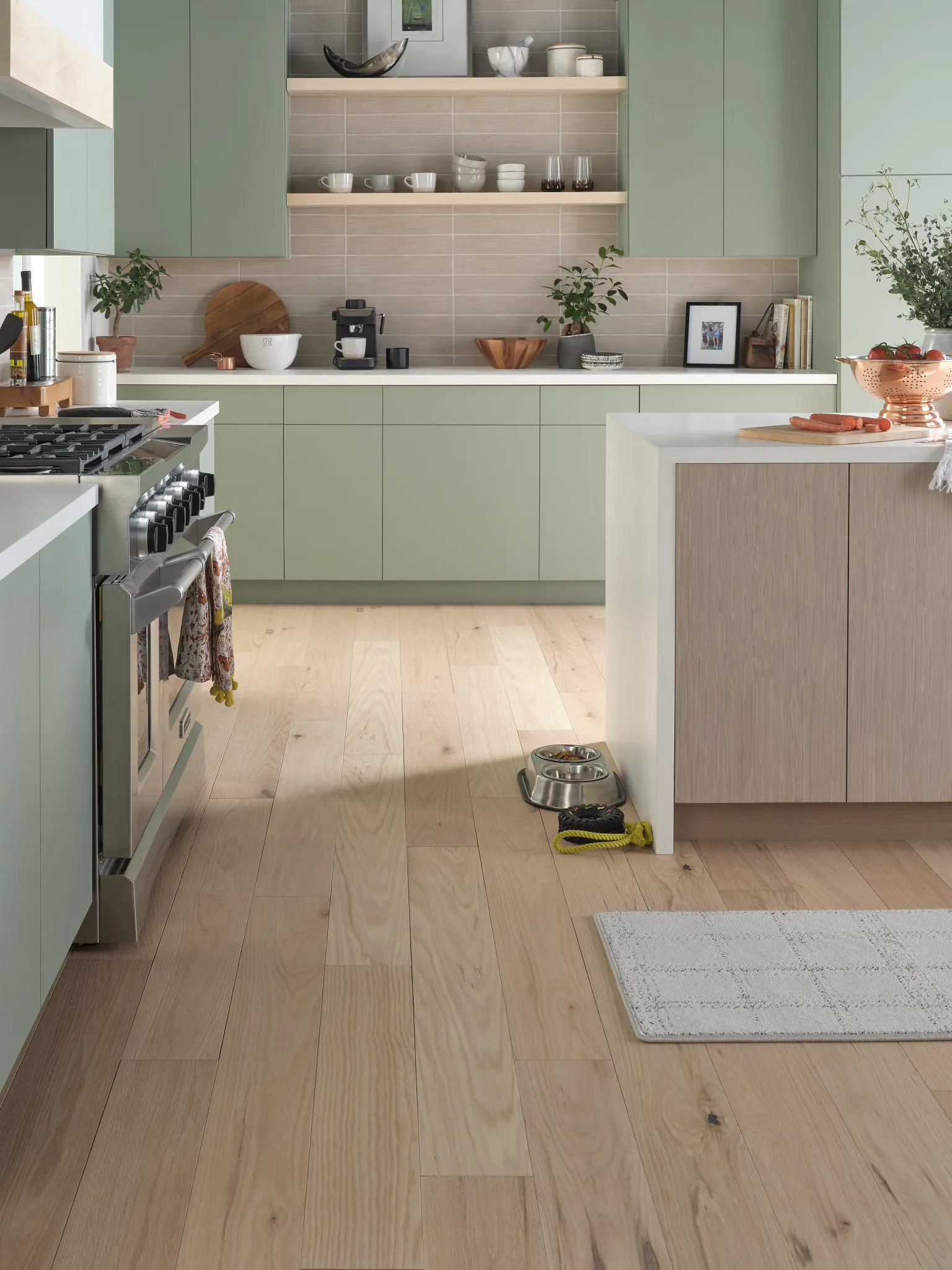 Modern kitchen with light wood flooring and mint green cabinets
