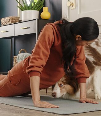 A woman doing yoga on a luxury vinyl floor with dog visible