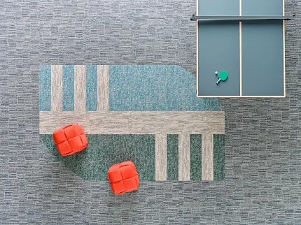 Stylish 18x36 inch carpet tiles for contemporary spaces Carpet tile flooring in a modern recreation area with ping pong table and red seating