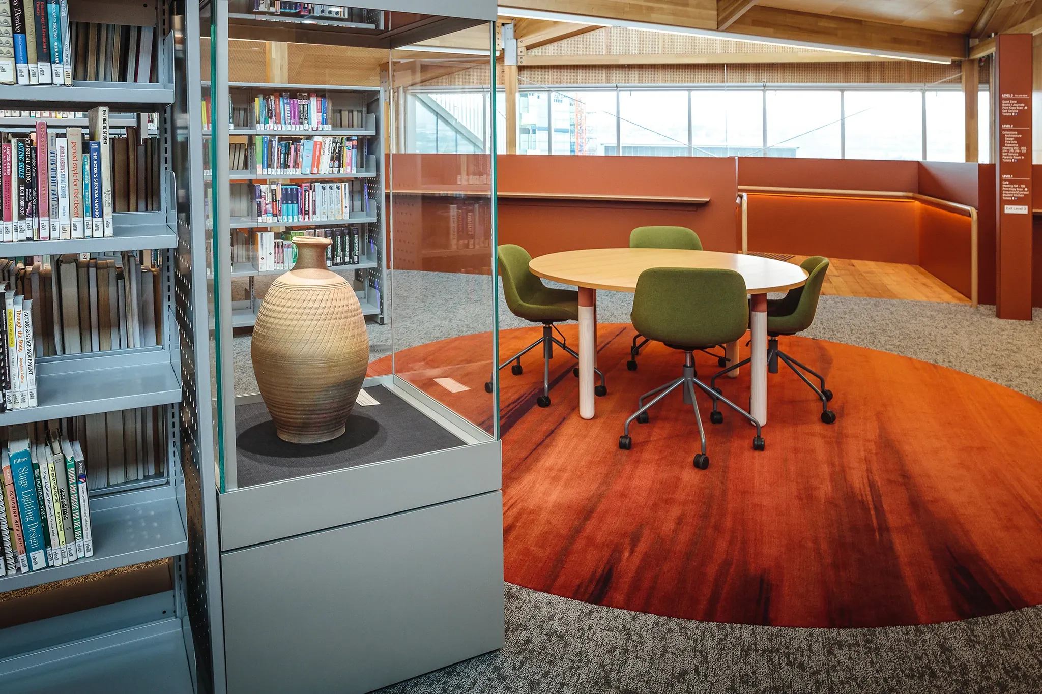 Custom flooring installation within the University of Tasmania library, featuring rich earthy tones, a cultural artefact display and collaborative learning spaces.