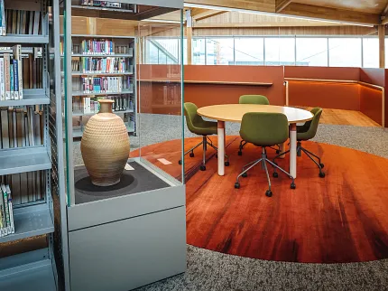 University of Tasmania Library Featuring Custom Flooring and Cultural Design | Shaw Contract Custom flooring installation within the University of Tasmania library, featuring rich earthy tones, a cultural artefact display and collaborative learning spaces.