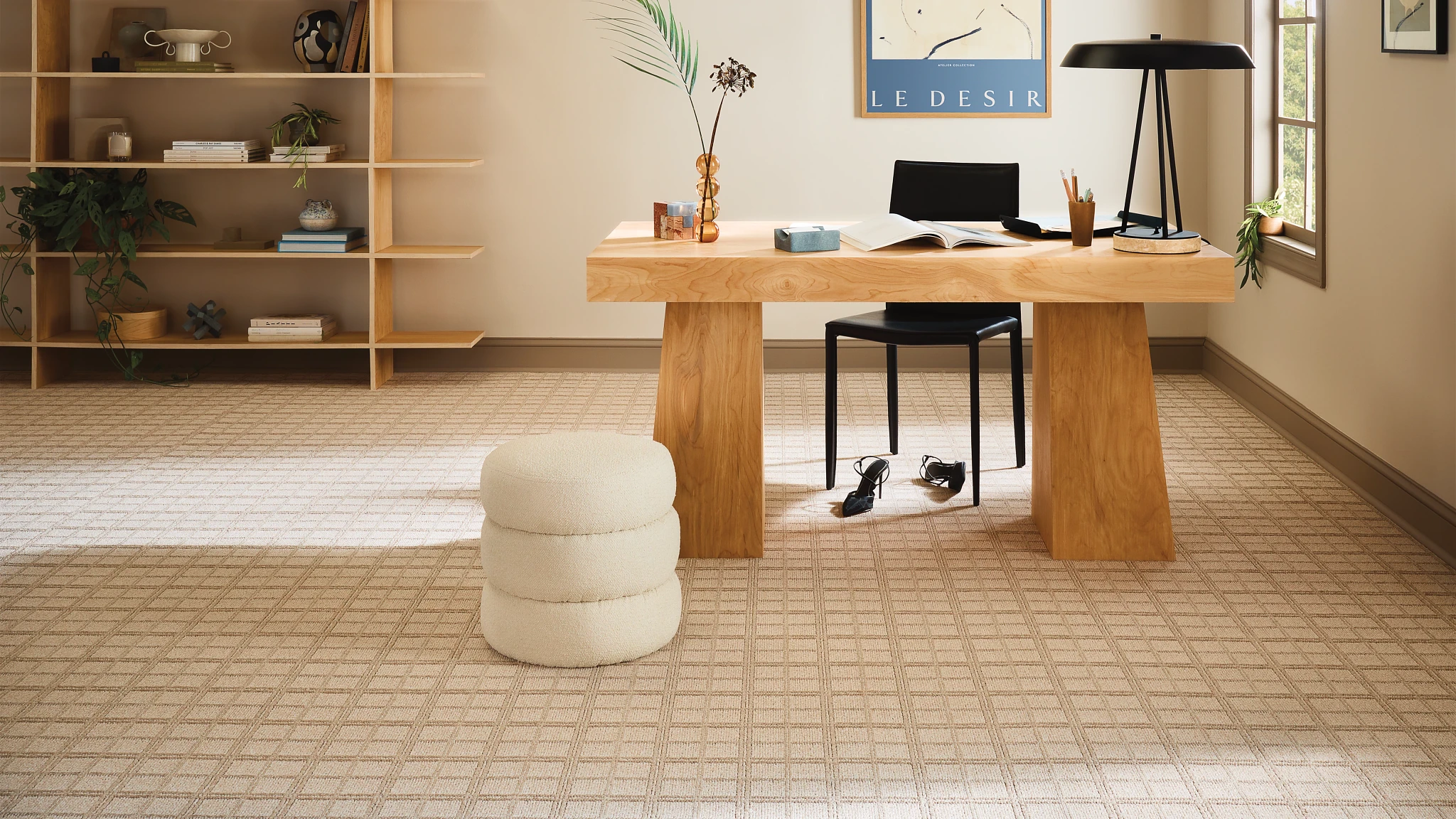 Modern office space with beige carpet flooring, wooden desk, and black chair