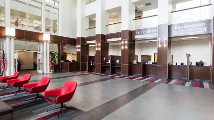 Healthcare Facility Lobby with Commercial Carpet Tile Flooring Modern healthcare facility lobby with red chairs and commercial carpet tile flooring in shades of gray and red