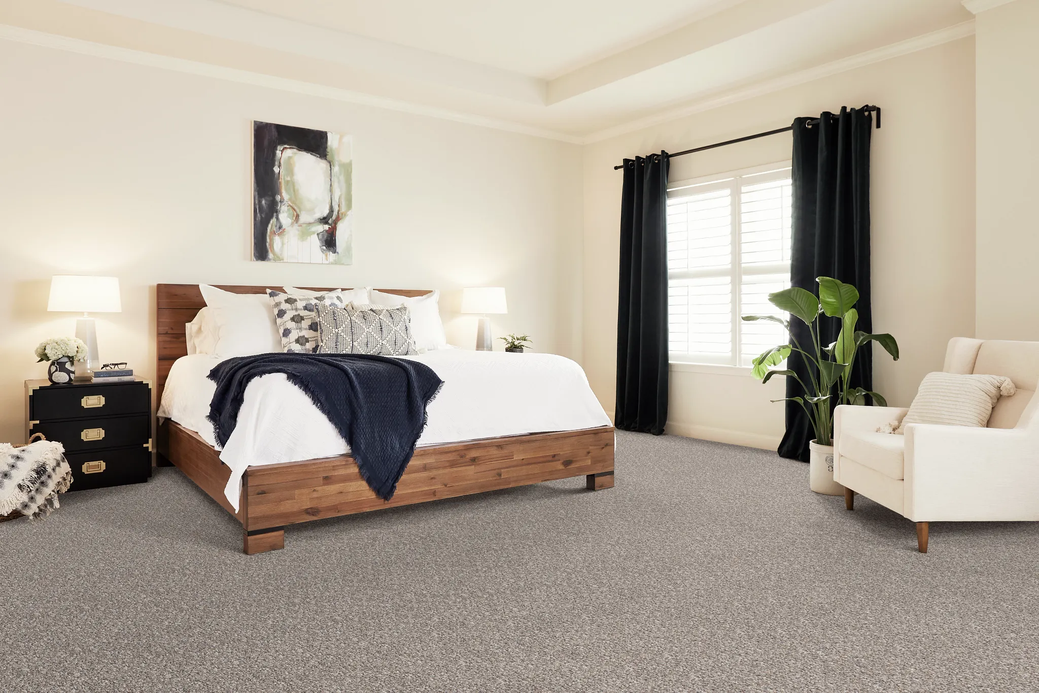 Cozy bedroom with neutral patterned carpet flooring, wooden bed frame, and modern decor