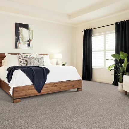 Comfortable and stylish bedroom with durable patterned carpet flooring Cozy bedroom with neutral patterned carpet flooring, wooden bed frame, and modern decor
