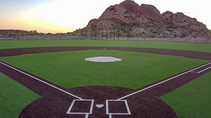 Synthetic turf baseball field with scenic view Baseball field with artificial turf and mountain backdrop