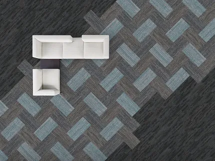 Modern Office Space with Patterned Commercial Carpet Tile in Blue, Gray, and Charcoal Overhead view of a modern office space featuring a white sectional sofa on a patterned commercial carpet tile floor in shades of blue, gray, and charcoal