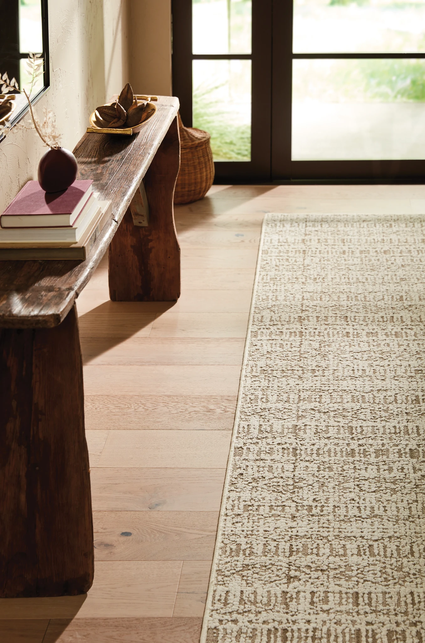 Elegant light hardwood flooring and beige patterned carpet in a stylish home entryway