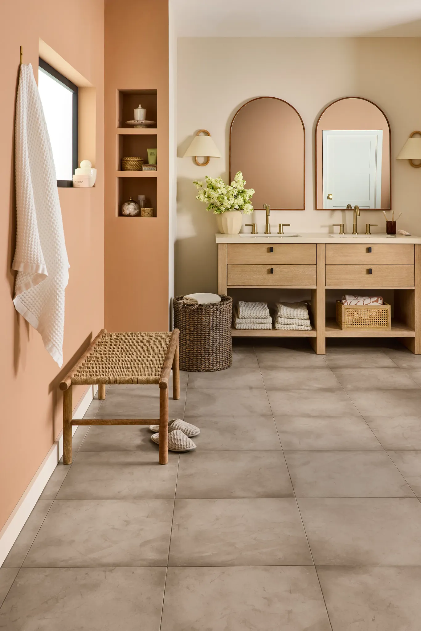 Modern bathroom with stone look luxury vinyl tile flooring, featuring a double vanity and woven basket decor.