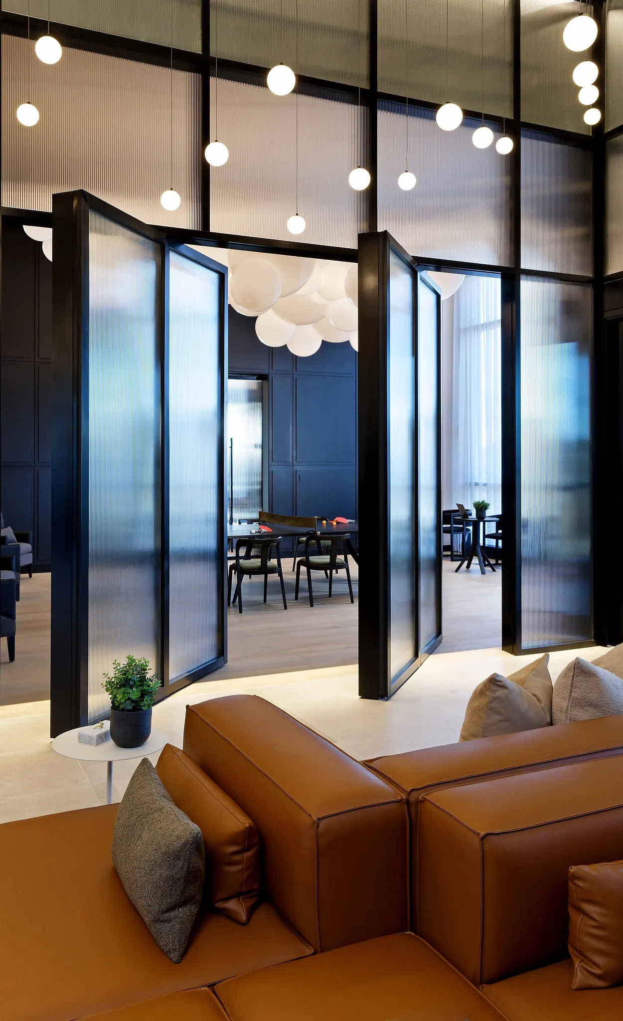 Modern office space with brown leather seating and frosted glass partitions