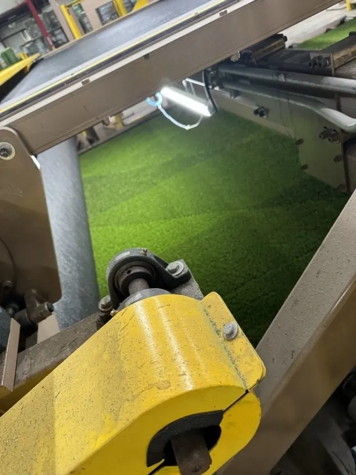 Green artificial turf production in factory setting