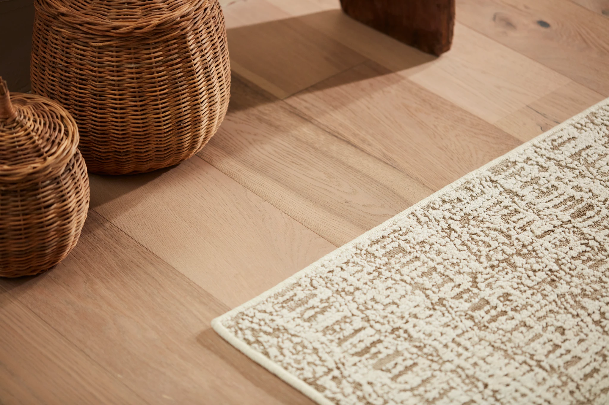 Area rug on a hardwood floor with baskets stacked around