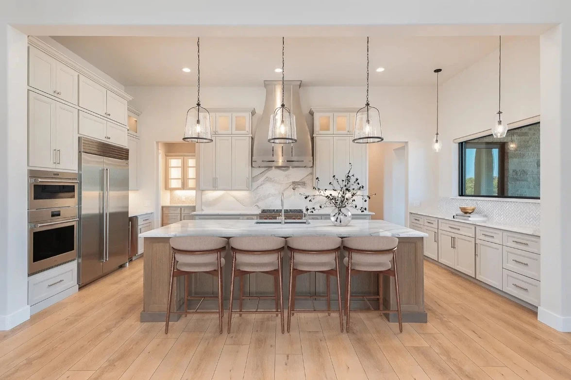 Modern kitchen with light wood look luxury vinyl plank flooring, featuring a spacious island and stainless steel appliances