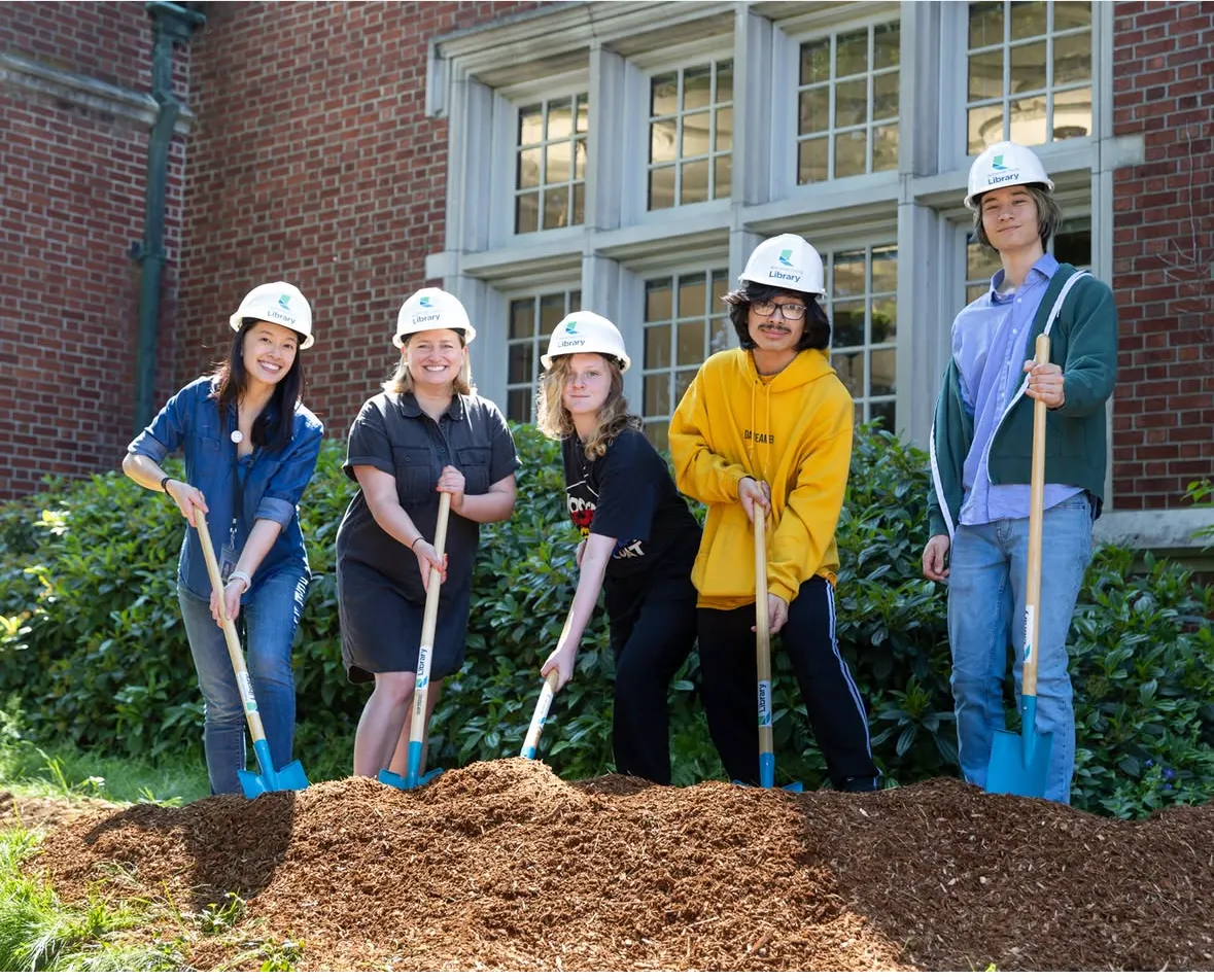 Group of people in hard hats participating in a groundbreaking ceremony