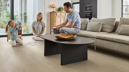 Light Wood Look LVP Flooring in Contemporary Living Room Scene Modern living room with family enjoying light wood look luxury vinyl plank flooring