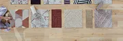 Carpet Tile Swatches Display on Wooden Floor Overhead view of diverse carpet tile swatches in various colors and patterns on a wooden floor with two people arranging them