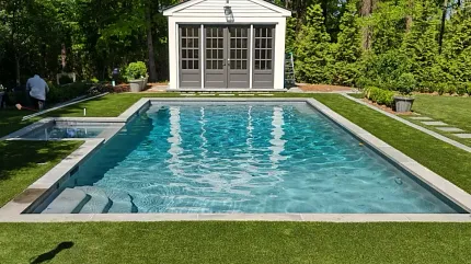 Serene backyard pool setting with lush landscape Outdoor pool with surrounding greenery and pool house