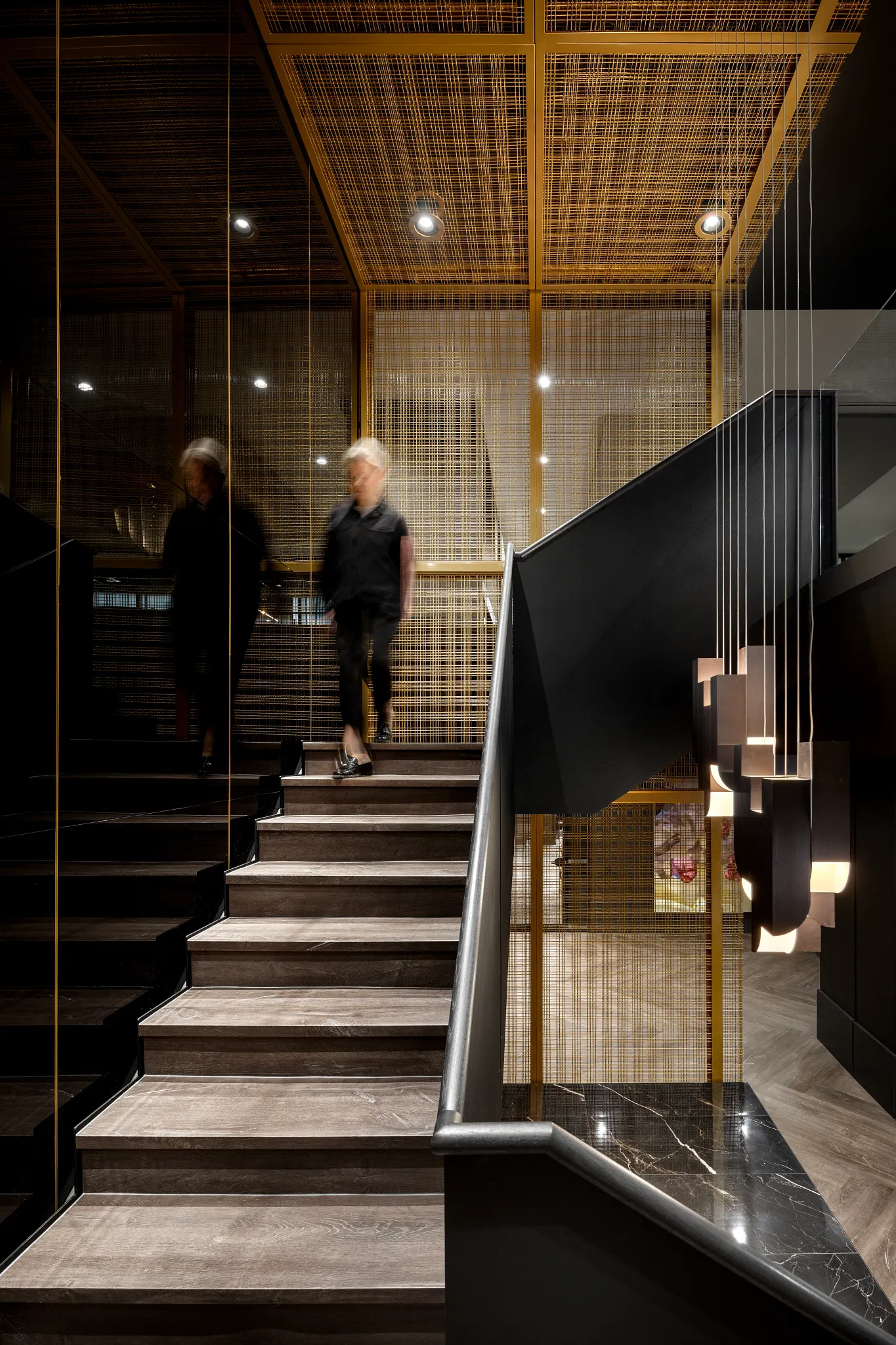 Modern staircase with wooden steps and black railing in a commercial building