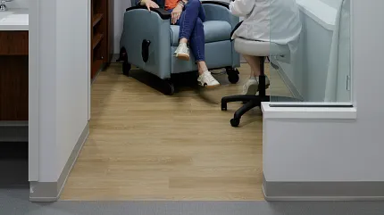 Healthcare Facility Consultation Room with Light Wood Flooring Healthcare Facility with light wood flooring and two people in a consultation room