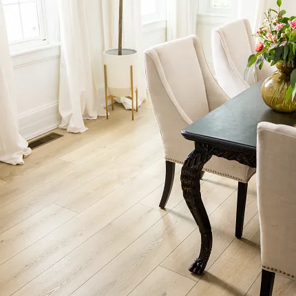 Stylish and durable vinyl flooring for sophisticated interiors Light wood look vinyl flooring in elegant dining room with Coretec Residential SPC construction