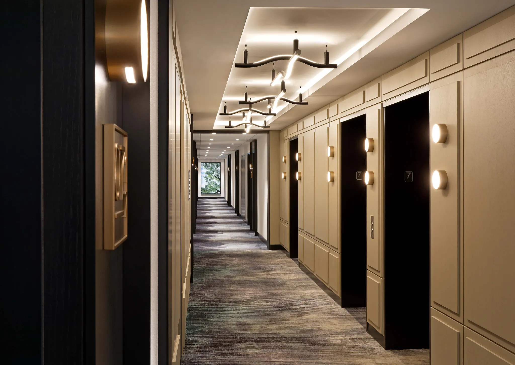 Modern hotel corridor with elegant lighting and patterned carpet flooring