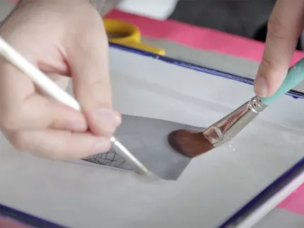 Artistic painting process captured in detail Close-up of hands painting on a tray