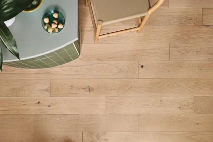 Premium Light Oak Hardwood Flooring for Contemporary Spaces Top view of a light oak hardwood flooring in a modern room with a green plant and a chair