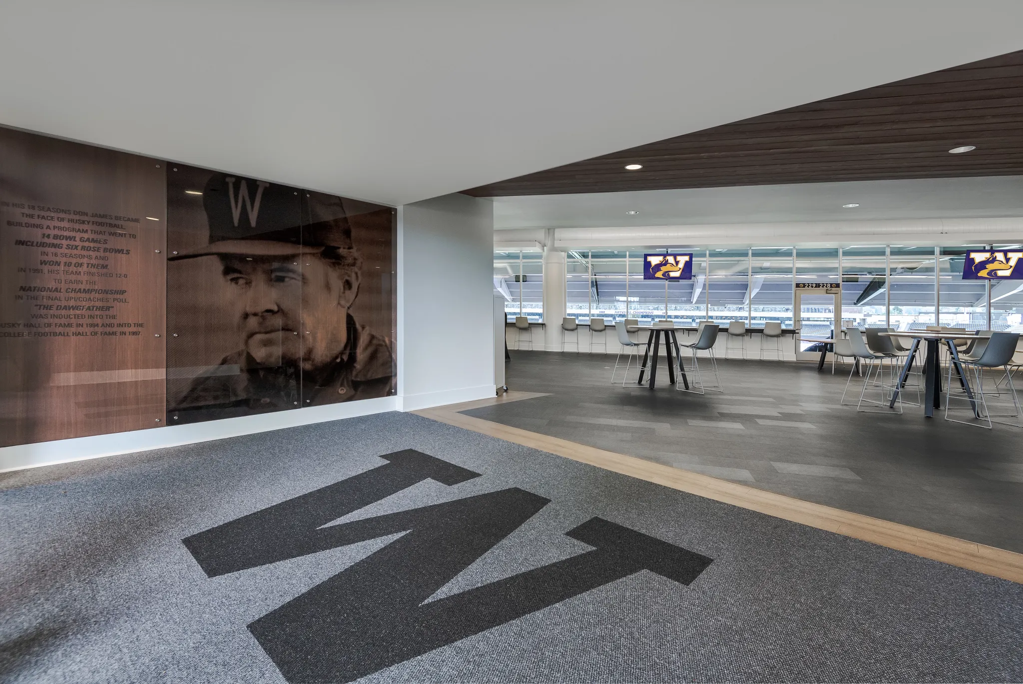 Modern education facility with large 'W' logo on commercial carpet tile and seating area with tables and chairs