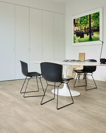 Light Wood Look Luxury Vinyl Plank Flooring in Modern Office Space Modern office space with light wood look luxury vinyl plank flooring, black chairs, and a white table