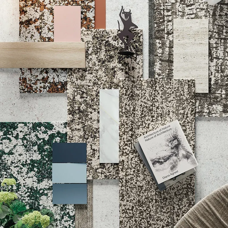 Assorted flooring swatches including beige, pink, blue, and green patterns with a book and decorative figure