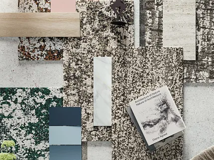Diverse flooring swatches with book and decorative figure display Assorted flooring swatches including beige, pink, blue, and green patterns with a book and decorative figure